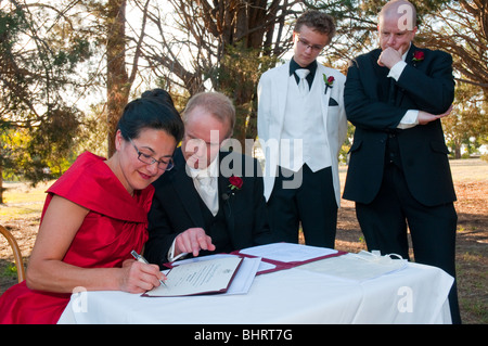A mature couple signent le registre à leur cérémonie de mariage civil en Australie Banque D'Images