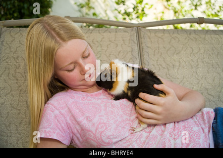 Portrait 10-11 ans, fille, détend, jouant avec sa détente sur cobaye en dehors de swing. United States Monsieur © Myrleen Pearson Banque D'Images