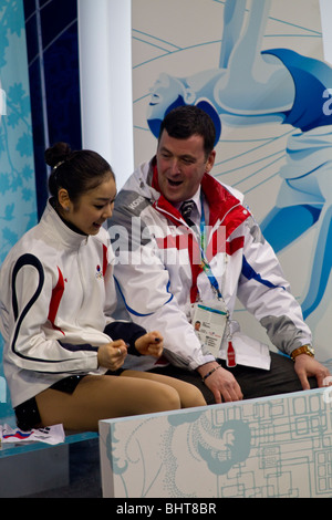 Yu-Na Kim (KOR) avec son entraîneur Brian Orser dans le baiser et pleurer après avoir participé dans le programme court dames de patinage artistique Banque D'Images