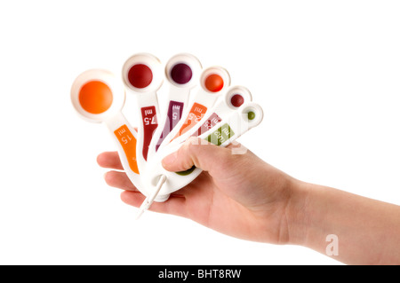 La main avec cuillères à mesurer Banque D'Images