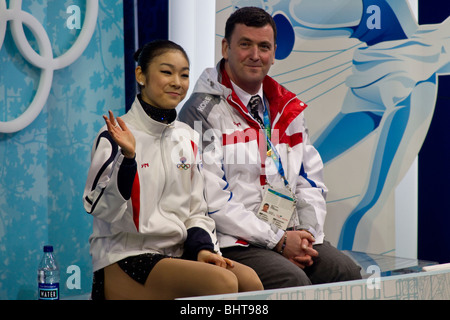 Yu-Na Kim (KOR) avec son entraîneur Brian Orser dans le baiser et pleurer après avoir participé dans le programme court dames de patinage artistique Banque D'Images