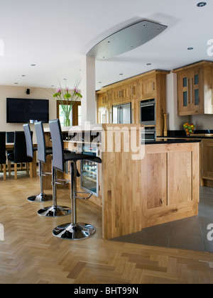 Selles noires au bar de petit-déjeuner dans la cuisine de campagne moderne avec parquet en bois clair et d'unités équipé Banque D'Images