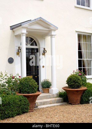 Maison de campagne traditionnel blanc clippé fort en pots de terre cuite d'un côté ou de porte avant avec porche à colonnes Banque D'Images