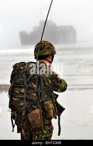 Les communications avec les engins de débarquement derrière, soldat avec les communications radio pendant un atterrissage plage, UK Banque D'Images