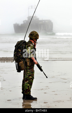 Les communications avec les engins de débarquement derrière, soldat avec les communications radio pendant un atterrissage plage, UK Banque D'Images