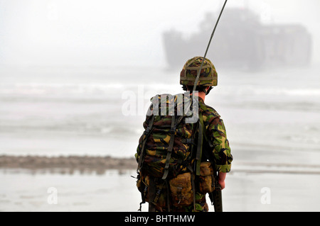 Les communications avec les engins de débarquement derrière, soldat avec les communications radio pendant un atterrissage plage, UK Banque D'Images