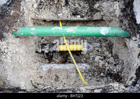 Nouveau tuyau de gaz domestique en plastique jaune prêt à être connecté à la nouvelle conduite principale. Le tuyau vert est pour la fibre optique. Banque D'Images