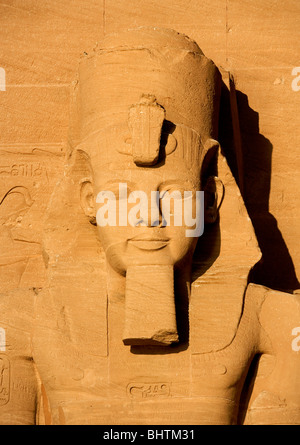 Statue de Ramsès II sculpté Garde la tête le grand temple d'Abou Simbel au lever du soleil en Egypte. Banque D'Images