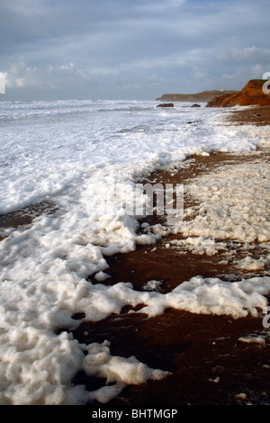 Sea Foam spume sur Widemouth Bay, Cornwall, Angleterre, Royaume-Uni. Banque D'Images