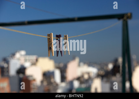 Trois des pinces à linge suspendu à un contre un ciel bleu sur la ville Banque D'Images