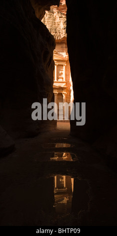 Le Conseil du Trésor ou Khaznah Al se reflétant dans les flaques à la ville antique de Pétra vu à travers le siq canyon à Wadi Musa, la Jordanie. Banque D'Images
