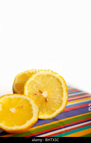 Tranches de citron frais sur plateau multicolores. Isolées. Copier l'espace. Banque D'Images