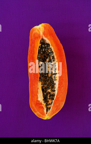 Couper la papaye avec graines contre fond violet Banque D'Images
