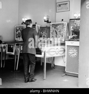 Homme jouant au flipper dans un Londres de jeux électroniques, c1966-67. Artiste : Henry Grant Banque D'Images