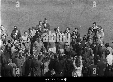 Les gagnants de la Coupe du Monde 1966 Angleterre Bobby Moore avec Trophy le 30 juillet 1966. Entouré par la presse, les membres de l'équipe de l'Angleterre se rassembler autour de leur propre "Captain Marvel", Bobby Moore, qu'il détient en altitude le trophée Jules Rimet. Le prix qui a marqué les champions du monde. Y2K le football. DTGU2 Banque D'Images