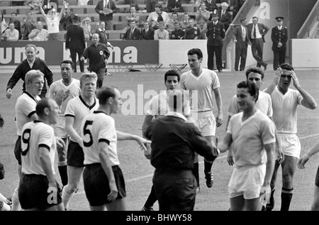 Coupe du Monde de Football 1966 en Allemagne de l'Ouest v Uruguay arbitre Jim Finney arrêtés Uruguays Horacio Troch hors du terrain après qu'il ait l'Allemagne fowled Emmrich dans la seconde moitié. ©1960 Mirrorpix Banque D'Images