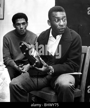 La star brésilienne du football Pelé à à une paire de chaussures de foot comme coéquipier Garrincha regarde sur. Le Brésil sont en Angleterre pour le Banque D'Images