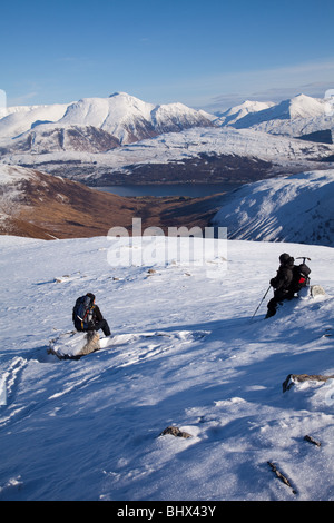 Deux marcheurs sur Stob Coire a'Chearcaill regardant le Ben Nevis et l'Mamores dans les Highlands écossais Banque D'Images