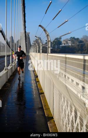 Homme jogger Bristol's passage célèbre pont suspendu, de-orientées pour créer des effets spéciaux. Banque D'Images