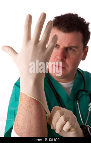 Man wearing scrubs medical stéthoscope et mettre sur une paire de gants en caoutchouc Banque D'Images