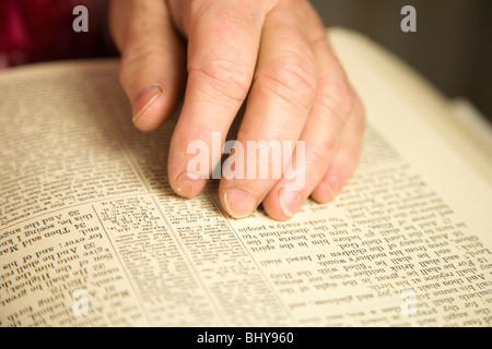 Mains de 67 ans woman reading bible Banque D'Images