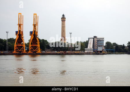 Phare et grues sur le côté droit de l'étroite rivière porcine, à Swinoujscie, Pologne Banque D'Images