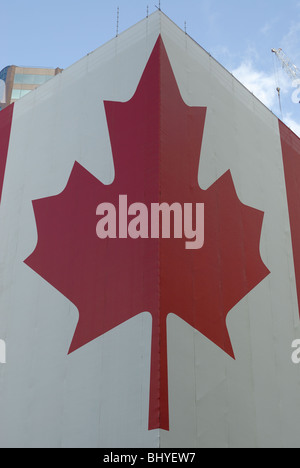 Très grand drapeau canadien enroulé autour d'un bâtiment. Banque D'Images