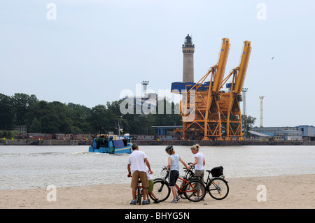 Phare et grues sur le côté droit de l'étroite rivière porcine, à Swinoujscie, Pologne Banque D'Images