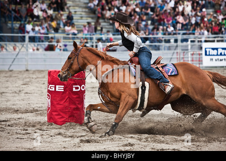 Cowgirl montant un cheval au cours de Rodeo Banque D'Images