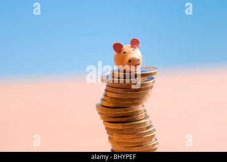 Cochon chanceux sur une pile de pièces de monnaie Banque D'Images