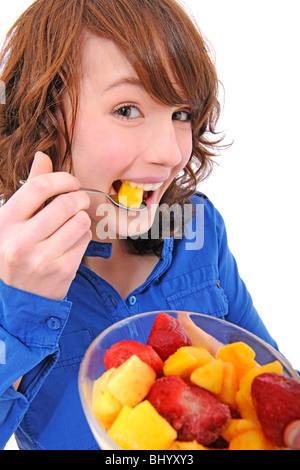 Jeune femme de manger une salade de fruits isolé sur blanc, décoration Banque D'Images