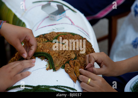 Projet d'art pour enfants. De nombreuses mains travaillant sur fête des fleurs pour décoration d'un char pour le 34e Festival des fleurs de Chiang Mai en Thaïlande du Nord, 2010 Banque D'Images