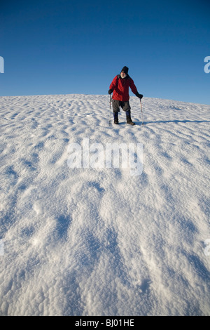 Randonneur plus Comergah d'escalade dans la neige des montagnes, comté de Waterford, Irlande Banque D'Images