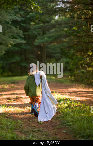 Jeune garçon portant une couverture dans les bois. Banque D'Images