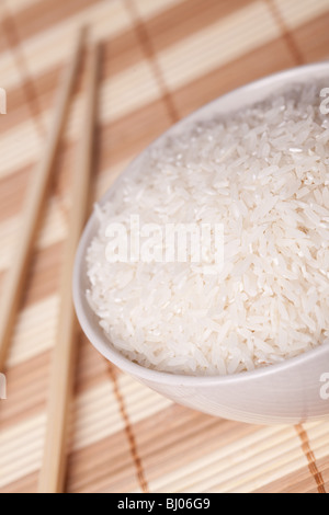 Dans un bol de riz blanc et baguettes sur la table Banque D'Images