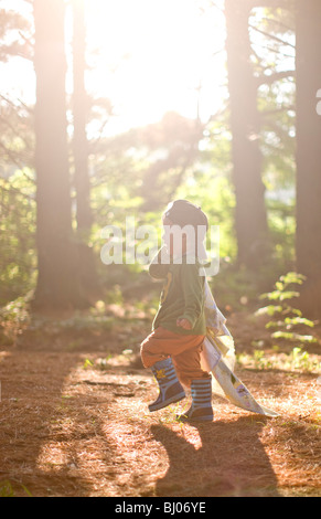 Jeune garçon portant une couverture dans les bois. Banque D'Images