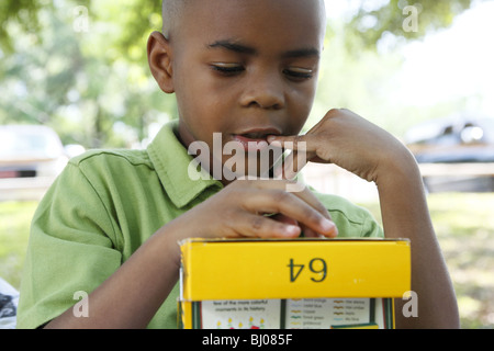 Enfant essayant de décider quelle couleur crayon à utiliser Banque D'Images