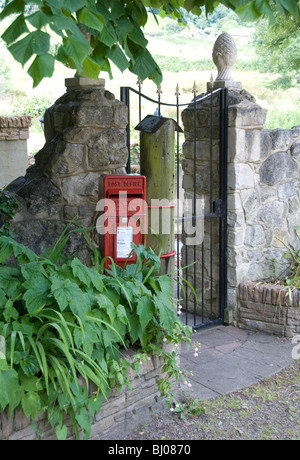 Red Royal Mail postbox en dehors d'une maison gate au Royaume-Uni Banque D'Images