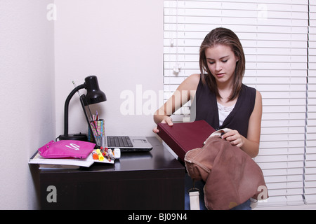 Teen girl chargement des fournitures scolaires en sac Banque D'Images