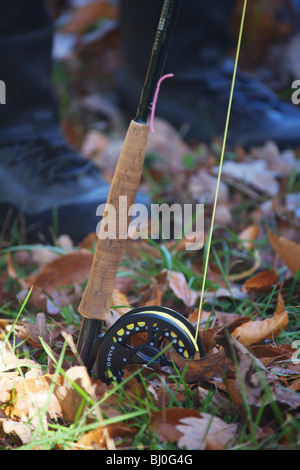 Vue rapprochée ORVIS FLY FISHING ROD REEL ASSIS SUR LES FEUILLES AU PIED DE FISHERMAN Banque D'Images