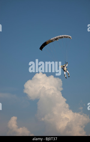 Parachutiste sous voile vole autour des nuages. La façon idéale de profiter de l'heure dans le ciel bleu avec un parachute. Banque D'Images