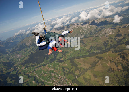 Effectuer un saut en tandem s'amuser ensemble et se sont sortis sur la précipitation dans le ciel bleu au-dessus de beaux paysages. Banque D'Images
