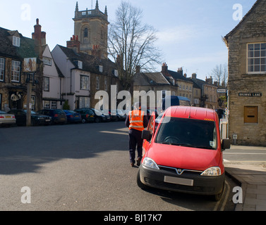 Un bureau de poste van livrer au bureau de poste à Woodstock, laissant la porte ouverte et parking sur double lignes jaunes Banque D'Images