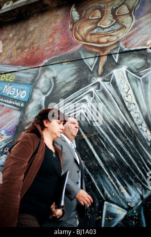 Couple walking cours des peintures murales d'Astor Piazzolla dans une rue du centre-ville de Buenos Aires, Argentine Banque D'Images