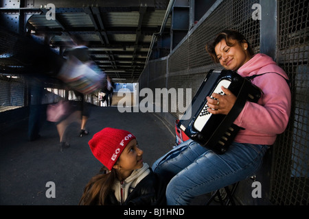 Street : musicion inmigrant roumaine avec sa fille à l'accordéon à la Friedrichstrasse S Bahn Berlin, Allemagne Banque D'Images