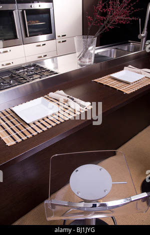 Cuisine moderne de couleur marron et blanc avec four double et petit déjeuner en face de la cuisinière Banque D'Images