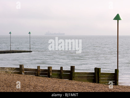 Épi en bois sur la plage à Leigh-on-Sea avec un navire à l'horizon. Leigh-on-Sea, Essex, Angleterre Banque D'Images