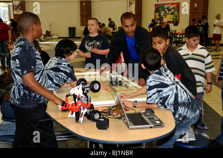 Les entraîneurs parent un groupe d'élèves de l'école de construction et test robot Lego. Banque D'Images