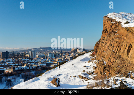 Les promeneurs sur la route ci-dessous Radical Salisbury Crags avec vue sur le château d'Édimbourg, Écosse, Royaume-Uni. Banque D'Images