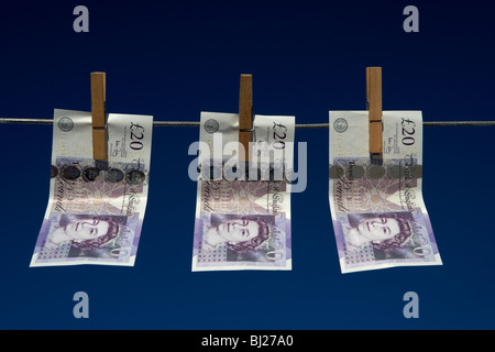 Trois billets de vingt livres sterling accroché à un lave-ligne avec ciel bleu Banque D'Images